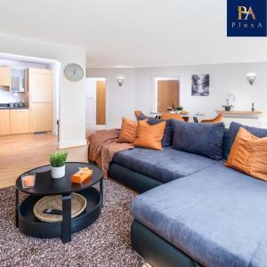 a living room with two blue couches and a table at Pluxa Sunstone Deluxe - Spacious Birmingham City Centre Stay in Birmingham