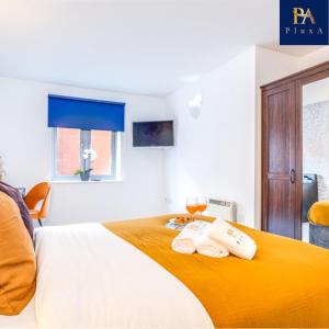 a bedroom with a bed with two towels on it at Pluxa Sunstone Deluxe - Spacious Birmingham City Centre Stay in Birmingham