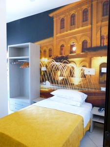 sypialnia z żółtym łóżkiem i obrazem budynku w obiekcie HOTEL D'ANNUNZIO w mieście Cattolica