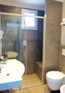 uma casa de banho com um chuveiro, um WC e um lavatório. em HOTEL D'ANNUNZIO em Cattolica