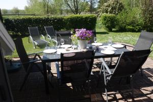 einen Tisch mit Stühlen und eine Vase mit Blumen darauf in der Unterkunft Ferienhaus Karlin in Börgerende-Rethwisch