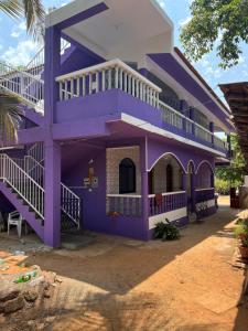 a purple house with white railings and stairs at Downtown in Calangute