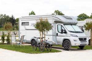 a white truck with bikes parked next to a caravan at Terme di Hissar Camping in Hisarya