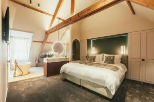 a bedroom with a large bed and a bathroom at Raphaëlles Boutique b&b in Bruges