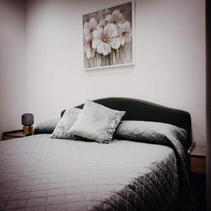 a bedroom with a bed with a flower picture on the wall at Piazza Vittoria Apartment in Carini