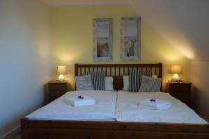 ein Schlafzimmer mit einem Bett mit zwei Handtüchern darauf in der Unterkunft Ferienhaus Karlin in Börgerende-Rethwisch
