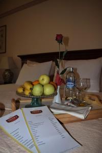 a table with a plate of fruit on a bed at Hotel Tivoli in Tetovo
