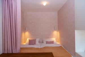 sypialnia z łóżkiem z białą pościelą i poduszkami w obiekcie Apartmán Kafe s postelí, střed Mikulova w mieście Mikulov