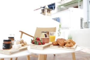 a table with two trays of bread and orange juice at VILLA CALLIOPE KEA in Ioulida +25 photos