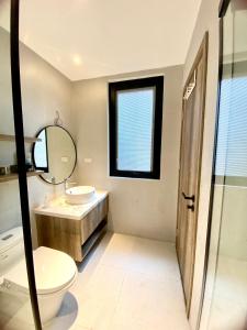 a bathroom with a toilet and a sink and a mirror at Sushi House Ba Dinh homestay alley38 Hang Bun in Hanoi