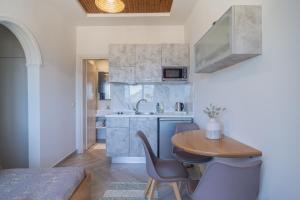 a kitchen with a table and chairs and a sink at Aris Apartments in Paleokastritsa