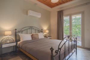 a bedroom with a large bed and a window at Aris Apartments in Paleokastritsa
