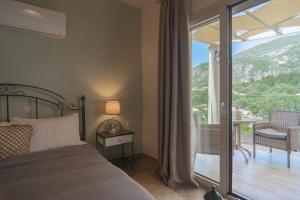 a bedroom with a bed and a balcony with a view at Aris Apartments in Paleokastritsa