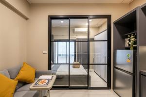 a living room with a couch and a sliding glass door at C2 stay Phayathai in Pom Prap