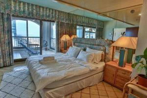 a bedroom with a large bed and a balcony at Orchid Hotel Beachfront 2BR Apartment in Tel Aviv