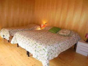 2 camas en una habitación con paredes de madera en La Mosa - Villa ai Prati di Cavedago, nel comprensorio del parco Adamello-Brenta, en Cavedago