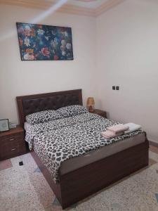 een slaapkamer met een bed met een bedsprei met luipaardprint bij Almarsa4 in Al Hoceïma