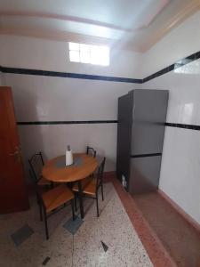 a room with a table and chairs and a refrigerator at Almarsa4 in Al Hoceïma