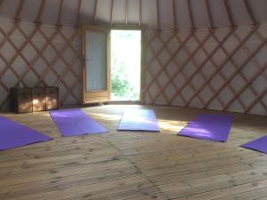 una habitación con esterillas de yoga púrpura en una yurta en Gites du Raby en Signes