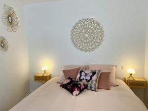 a white bed with pillows on it with two lamps at La petite Maison Messigny in Messigny-et-Vantoux