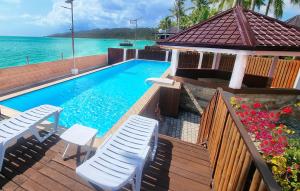 una piscina con sedie e l'oceano sullo sfondo di EL Rancho Beach Hotel a San Francisco