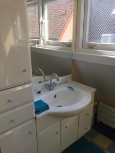 een badkamer met een wastafel en een raam bij Holiday in Spakenburg t Afferhuus in Spakenburg