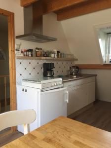 a kitchen with a white stove top oven next to a table at Holiday in Spakenburg t Afferhuus in Spakenburg +8 photos
