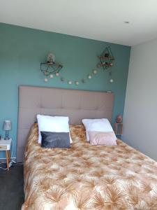 a bedroom with a large bed with two pillows at Maison architecte in Romilly-sur-Andelle