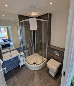 a bathroom with a shower and a toilet and a sink at Modern apartment, sleeps 6, Belfast city centre in Belfast