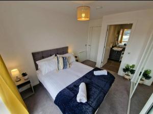 a bedroom with a bed with two white towels on it at Modern apartment, sleeps 6, Belfast city centre in Belfast