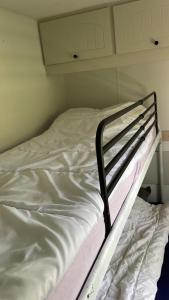 a bed with white sheets and a black frame at Chalet 4-6 personen op 5* camping Terspegelt in Eersel