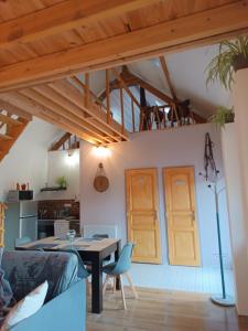 a living room with wooden ceilings and a table and chairs at L'écurie in Méneslies +28 photos