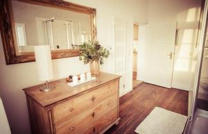 a room with a dresser with a mirror and a lamp at Schloss Altenhagen in Kröpelin