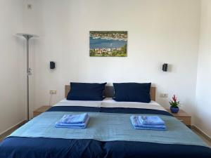 een slaapkamer met een blauw bed met 2 handdoeken erop bij Superior Rooms Sea Side View in Rab