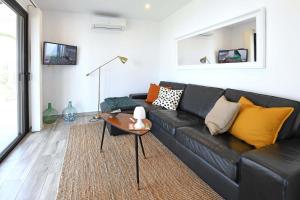 sala de estar con sofá negro y almohadas amarillas en Casa El Consuelo, en Tijarafe