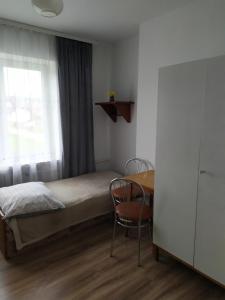 1 dormitorio con cama, mesa y ventana en Agroturystyka u Marty en Tylicz