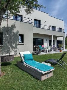 a house with two chaise lounges on the lawn at Maison architecte in Romilly-sur-Andelle