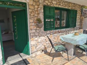 a table and chairs in front of a stone wall at Villa Mia Filomena in Sevid