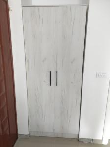 a white door with black handles in a room at Apartman Centar Bar in Bar