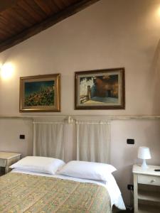 a bedroom with a bed with two pictures on the wall at Il Capisterium in Norcia