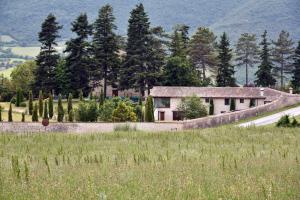 uma casa num campo ao lado de uma estrada em Il Capisterium em Norcia