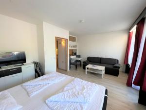 ein Schlafzimmer mit einem Bett und ein Wohnzimmer in der Unterkunft Ferienpark Sierksdorf App 580 - Strandlage in Sierksdorf