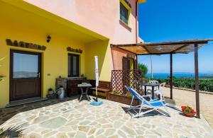 un patio de una casa con mesa y sillas en Agriturismo Finagliosu, en Palmadula