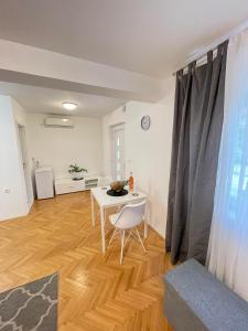 a living room with a white table and a chair at Apartment Maria in Zadar