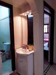 y baño con lavabo y espejo. en Maison Othmane en Esauira
