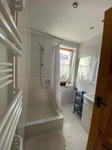 biała łazienka z prysznicem i wanną w obiekcie Dom Wypoczynkowy Karina w Łebie