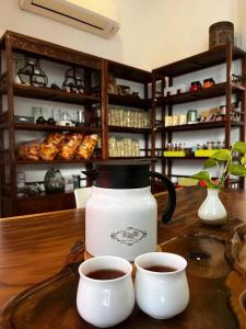 a coffee pot and two cups of coffee on a table at S8 Boutique Hotel near KLIA 1 & KLIA 2 in Sepang
