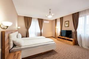 a bedroom with a large bed and a television at Goldenburg Residence in Plovdiv