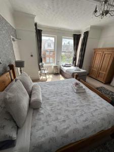 um quarto com uma cama grande e uma janela grande em Baytree House em Lowestoft