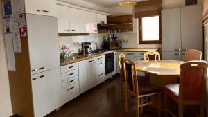 a kitchen with white cabinets and a table and chairs at Casa Linistita in Chişcău